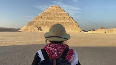 Mısır, Saqqara 'daki piramidin önünde duran kadının arka görüntüsü. Yüksek kalite fotoğraf