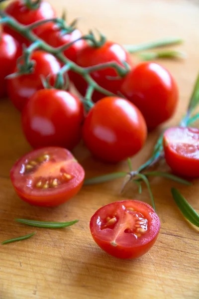 Pomidory na brązowym drewnie teksturowanym — Zdjęcie stockowe