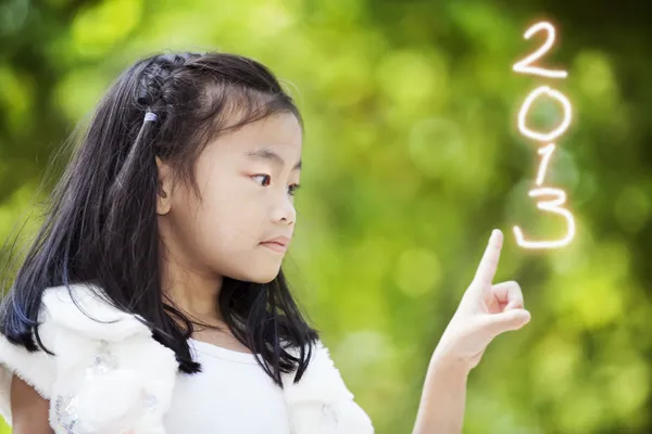 Niña escribir los números 2013 — Foto de Stock