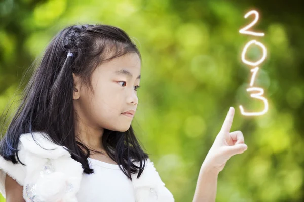 Kleines Mädchen schreibt die Zahlen 2013 — Stockfoto