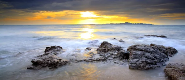 Grande onda e la roccia con il cielo al tramonto — Foto Stock