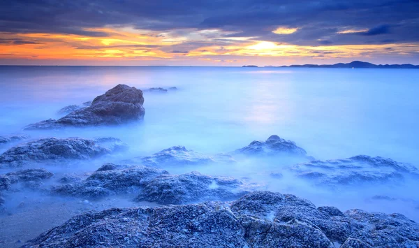 Büyük dalga ve günbatımı gökyüzü ile kaya — Stok fotoğraf