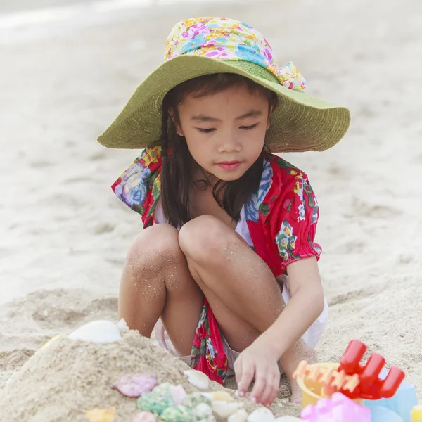 Chica está jugando con sus juguetes en la playa — Foto de Stock
