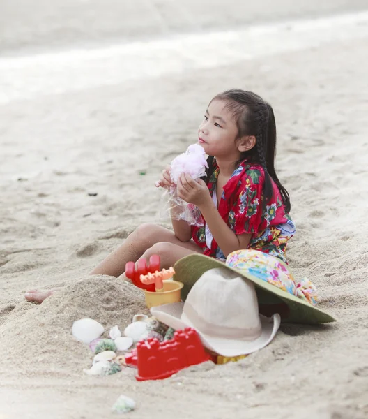 Fille joue avec ses jouets sur la plage — Photo