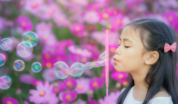 Asiatisches kleines Mädchen bläst Seifenblasen — Stockfoto