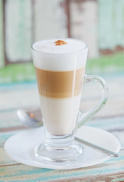 Schaumiger, geschichteter Cappuccino im Klarglasbecher — Stockfoto
