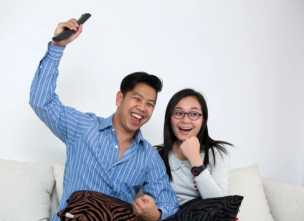 Ungt par tittar på TV hemma — Stockfoto