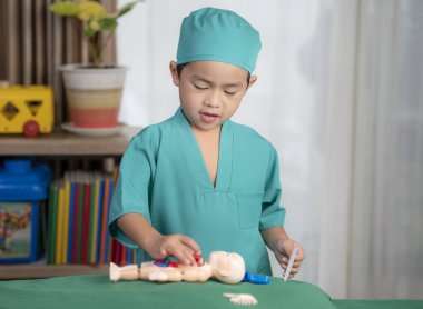 Asian boy play surgery with toy, he have dream for do a doctor job in future