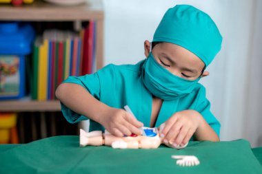 Asian boy play surgery with toy, he have dream for do a doctor job in future