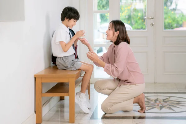 在上学前 亚洲家庭 母亲和儿子在校服之间喝牛奶 — 图库照片