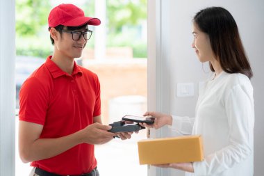 Asyalı postacı müşteriye posta kutusu teslim eder. Bu resim online alışveriş ve teslimat konsepti için kullanılabilir.