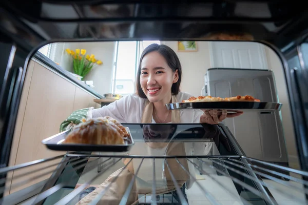 家庭の台所でオーブンで自家製ピザを作ったアジアの女性 オーブンの内部からの眺め — ストック写真