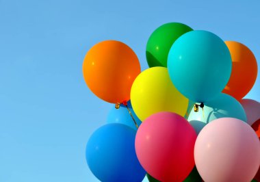 Şehir festivalinde açık mavi arka planda bir grup renkli balon