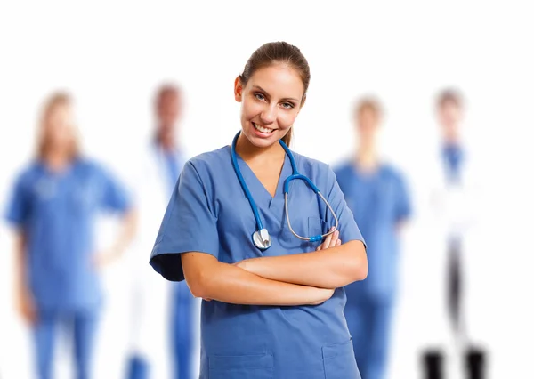 Hermosa enfermera frente a su equipo médico —  Fotos de Stock