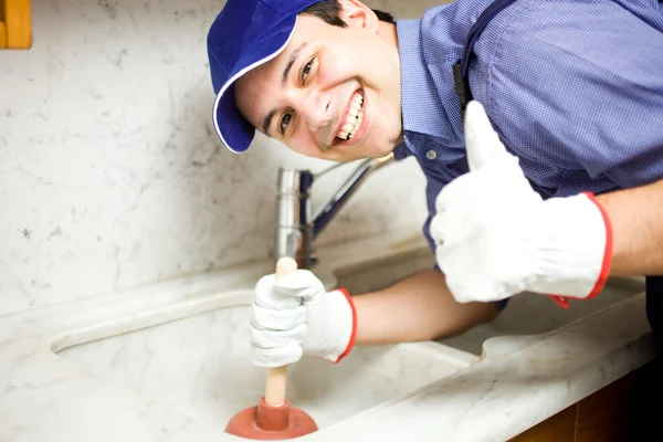 Lachende loodgieter op het werk — Stockfoto