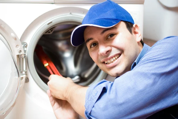 Çamaşır makinesini tamir eden teknisyen. — Stok fotoğraf