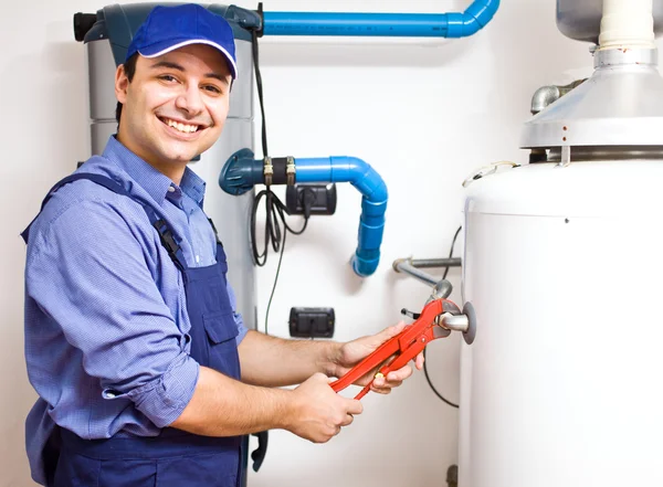 Técnico reparando un calentador de agua caliente — Foto de Stock