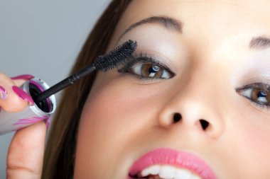 kadın yüzünü rimel fırçası ile yakın çekim