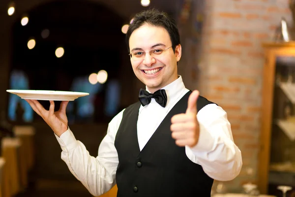Официант держит тарелку — стоковое фото