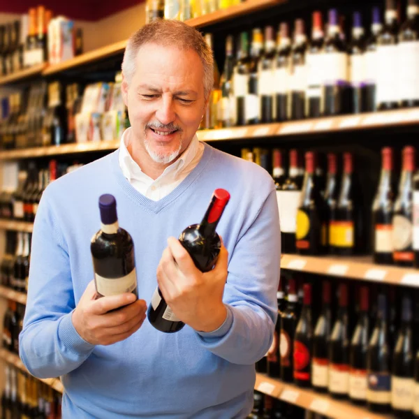 Homem escolhendo vinho — Fotografia de Stock