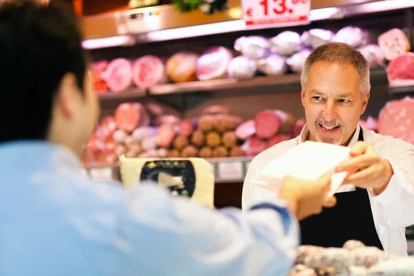 Ladenbesitzer, der einem Kunden dient — Stockfoto