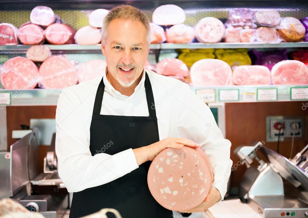 Shopkeeper holding bologna — Stock Photo © minervastock 23283744
