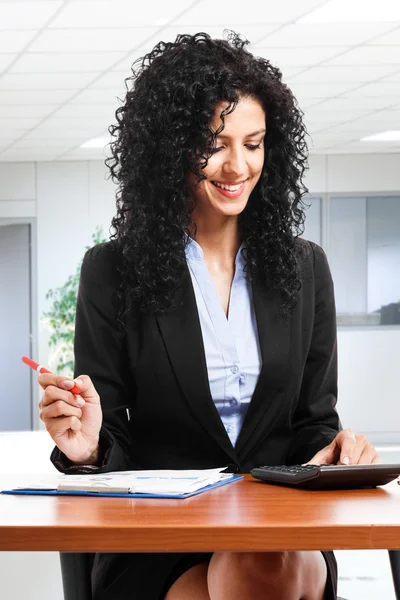 Empresária sorridente usando uma calculadora — Fotografia de Stock