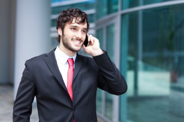 Yakışıklı iş adamı telefonda konuşuyor.