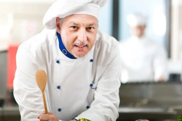 Улыбающийся шеф-повар на кухне — стоковое фото