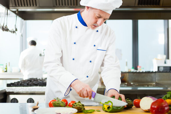 Friendly chef preparing vegetables in his kitchen