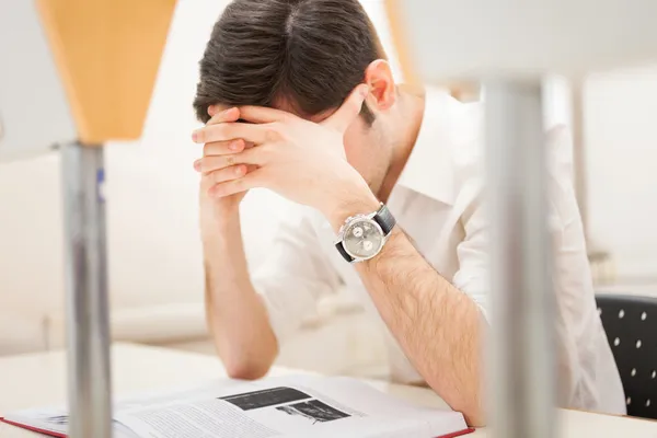 Stressad student som läser en bok — Stockfoto