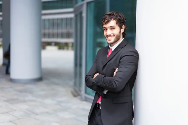 Businessman leaning on a column — Stock Photo, Image