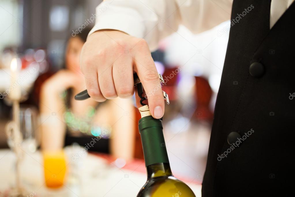 Waiter uncorking a wine bottle