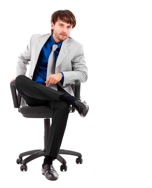 Porträtt av smarta unga manliga executive sitter på stol isolerad på vit — Stockfoto