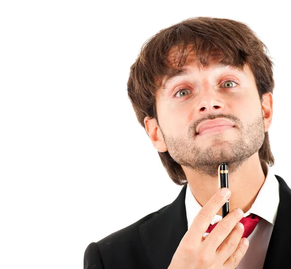 Un uomo d'affari premuroso che tiene una penna sul mento isolato su bianco — Foto Stock