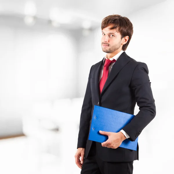 Portrait d'un jeune homme d'affaires prospère dans un environnement de bureau tenant un presse-papiers — Photo