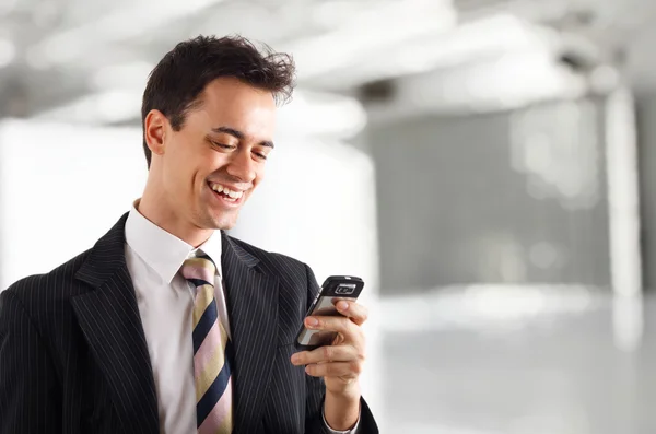 Bonito homem de negócios usando um smartphone . — Fotografia de Stock