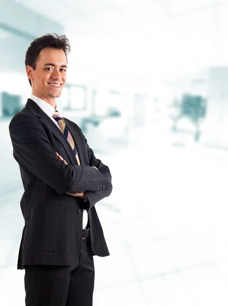 Joven hombre de negocios sonriendo. Fondo brillante borroso . —  Fotos de Stock