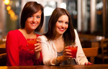 iki genç kadın bir barda bir içki tadını çıkarıyor