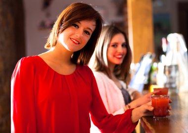 iki genç kadın bir barda bir içki tadını çıkarıyor