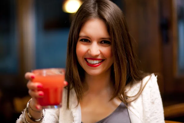 Junge Frau bei einem Drink in einer Kneipe — Stockfoto