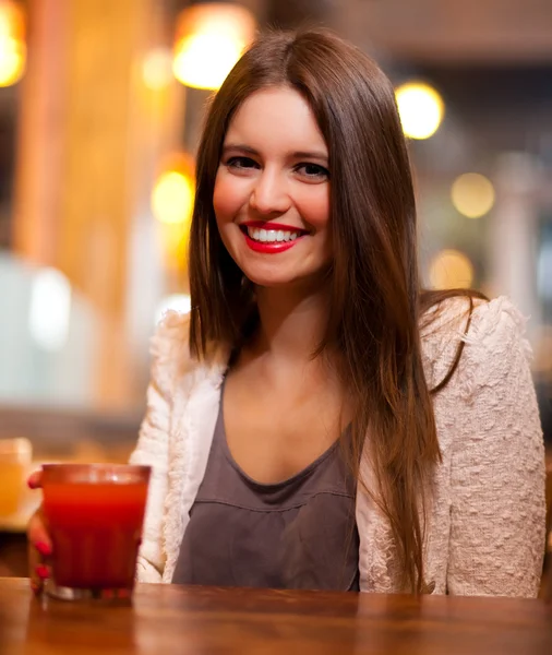 Young woman having a drink in a pub — Stock Photo, Image