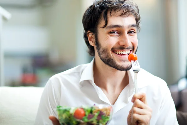 Ung man äta en hälsosam sallad — Stockfoto