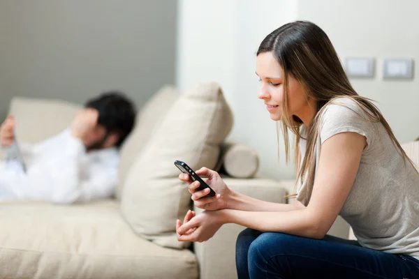 Paar ontspannen op de sofa met smartphone — Stockfoto