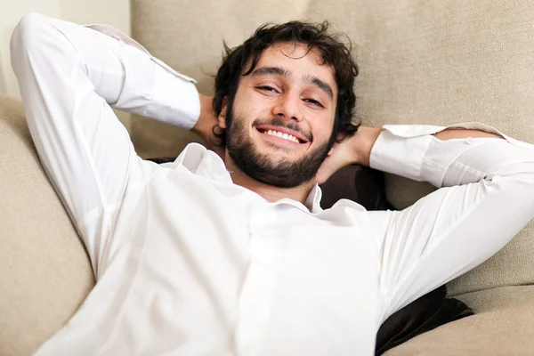 Hombre joven relajándose en el sofá — Foto de Stock