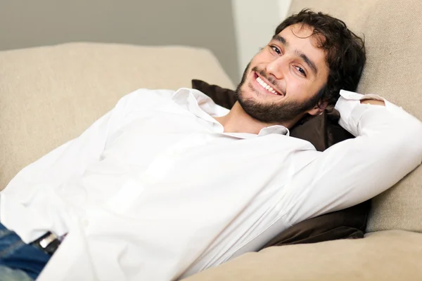 Νεαρός άνδρας χαλαρωτικό στον καναπέ — Φωτογραφία Αρχείου
