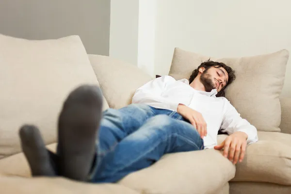 Ember pihentető a kanapén — Stock Fotó
