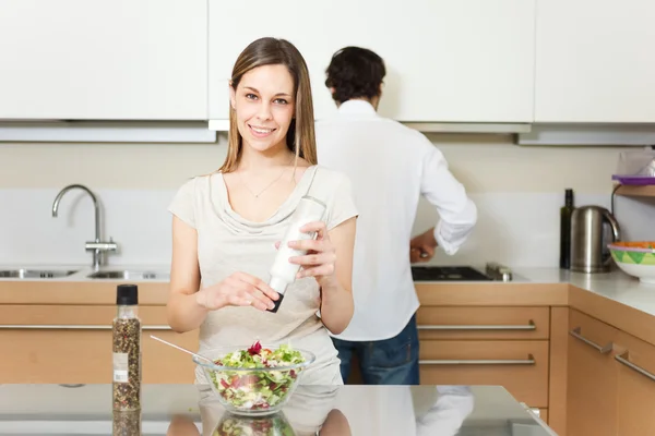 Woman spicing a salad — Stock Photo, Image