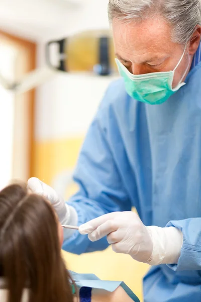 Dentista curando a una paciente femenina — Foto de Stock