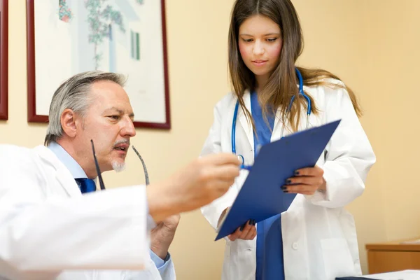 Retrato de um médico e seu assistente em seu estúdio — Fotografia de Stock